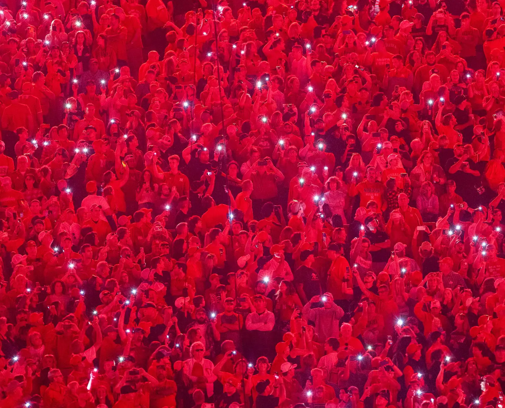 fans in stadium with flashlights up